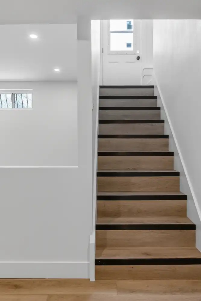 Finished staircase leading down to a developed basement
